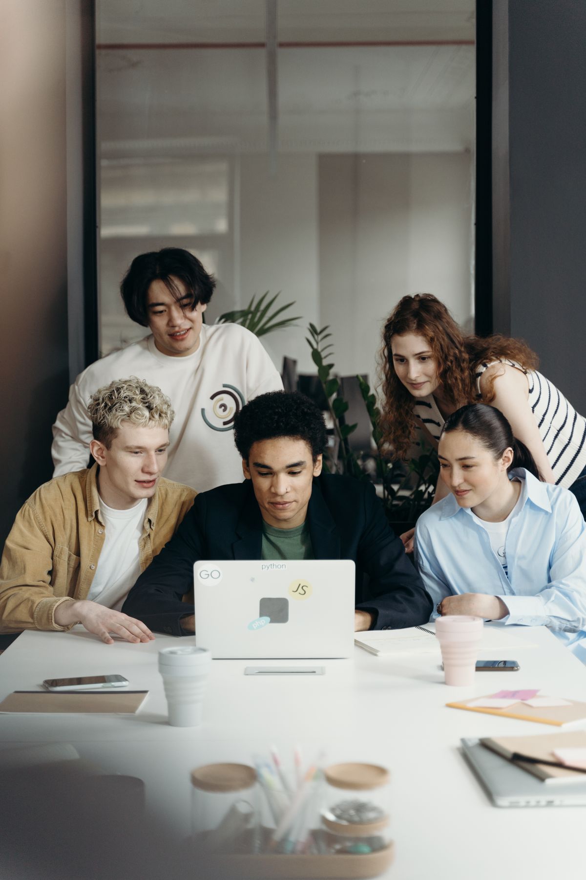 Colleagues collaborating around a laptop in a shared office